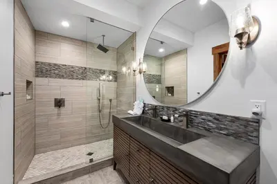 a bathroom with a shower and a sink and a mirror at Fly Rod Inn – Two Large Patios, Jacuzzi and Indoor/Outdoor Fireplace in Estes Park