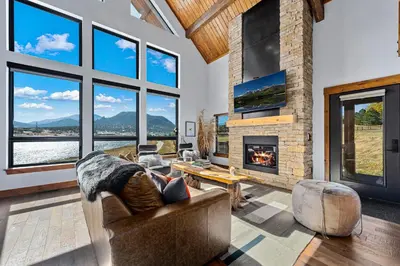 a living room with a couch and a fireplace at Fly Rod Inn – Two Large Patios, Jacuzzi and Indoor/Outdoor Fireplace in Estes Park