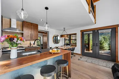 an open kitchen with a counter and stools at End Unit - EV Charger, Fireplace & Jacuzzi in Estes Park