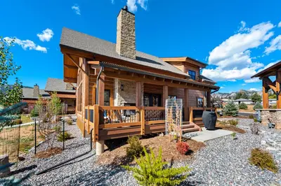 a log home with a deck and a house at End Unit - EV Charger, Fireplace & Jacuzzi in Estes Park