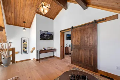 a large room with a wooden door and a desk at End Unit - EV Charger, Fireplace & Jacuzzi in Estes Park