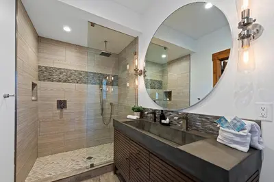 a bathroom with a shower and a large mirror at End Unit - EV Charger, Fireplace & Jacuzzi in Estes Park