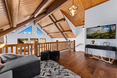 a living room with a couch and a tv on the wall at Estes Retreat – Indoor/Outdoor Fireplace, Jacuzzi, Close to Downtown Estes in Estes Park