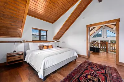 a bedroom with a bed and a large window at Estes Retreat – Indoor/Outdoor Fireplace, Jacuzzi, Close to Downtown Estes in Estes Park