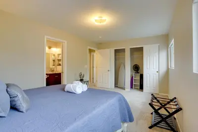a bedroom with a blue bed and a kitchen at Denver Getaway Close to Downtown, Mtns, and Boulder in Thornton