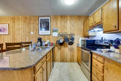a kitchen with wooden cabinets and a counter top at Mtn Condo with Ski Locker and Pools - 3 Mi to Resort! in Winter Park