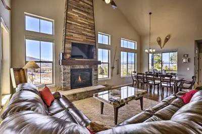 a living room with a leather couch and a fireplace at Ski-InandOut Granby Home with Gas Grill and Fire Pit! in Granby