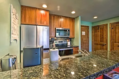 a kitchen with stainless steel appliances and wooden cabinets at Couples Ski Condo 1 Mi to Breckenridge Golf Club in Breckenridge