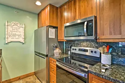a kitchen with stainless steel appliances and wooden cabinets at Couples Ski Condo 1 Mi to Breckenridge Golf Club in Breckenridge