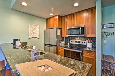a kitchen with stainless steel appliances and wooden cabinets at Couples Ski Condo 1 Mi to Breckenridge Golf Club in Breckenridge