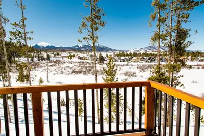 a deck with a view of the snow covered mountains at Cozens Pointe E 102 condo in Fraser