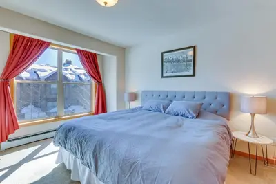 a bedroom with a large bed and a window at Airy Winter Park Gem with Private Outdoor Hot Tub! in Winter Park