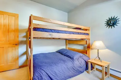 a bedroom with a bunk bed and a table and a lamp at Airy Winter Park Gem with Private Outdoor Hot Tub! in Winter Park
