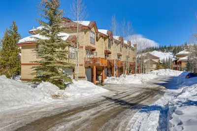 a house on a snow covered road in front of a house at Airy Winter Park Gem with Private Outdoor Hot Tub! in Winter Park