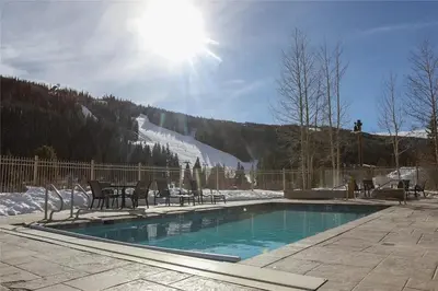a swimming pool with tables and chairs in the snow at Full Renovated 1BR -Walk to Gondola & Kids Ski Free condo in Dillon