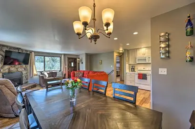 a dining room and living room with a table and chairs at Luxe Updated Home with Grill and Hot Tub 4 Mi to RMNP in Estes Park