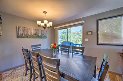 a dining room with a wooden table and chairs at Luxe Updated Home with Grill and Hot Tub 4 Mi to RMNP in Estes Park