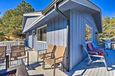 a blue tiny house with chairs on a deck at Luxe Updated Home with Grill and Hot Tub 4 Mi to RMNP in Estes Park