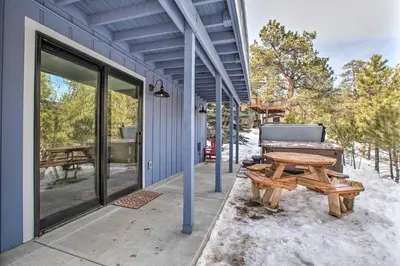 a patio with a picnic table and a bench at Luxe Updated Home with Grill and Hot Tub 4 Mi to RMNP in Estes Park