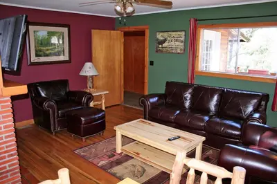 a living room with a leather couch and a coffee table at Mountain Pine Cabin by Rocky Mountain Resorts- #20NCD0296 in Estes Park
