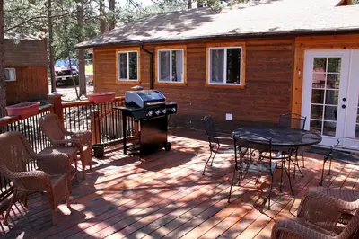 a patio with a grill and a table and chairs at Mountain Pine Cabin by Rocky Mountain Resorts- #20NCD0296 in Estes Park