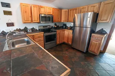 a kitchen with wooden cabinets and a stainless steel refrigerator at Rocky Mountain Retreat 2 by Rocky Mountain Resorts in Estes Park