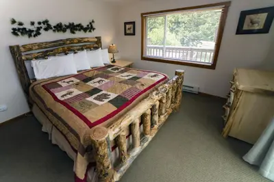 a bedroom with a bed with a quilt on it at Rocky Mountain Retreat 1A by Rocky Mountain Resorts in Estes Park
