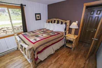 a bedroom with a bed and a lamp and a window at Rocky Mountain Retreat 1A by Rocky Mountain Resorts in Estes Park