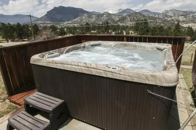 a hot tub on a deck with a chair at Rocky Mountain Retreat 1A by Rocky Mountain Resorts in Estes Park