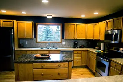 a kitchen with wooden cabinets and a sink and a window at Virginia Home by Rocky Mountain Resorts- #3106 in Estes Park