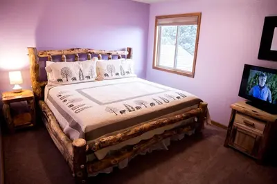 a bedroom with a wooden bed and a television at Virginia Home by Rocky Mountain Resorts- #3106 in Estes Park