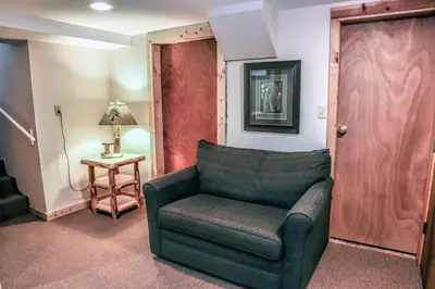 a living room with a green chair and a table at Stonehaven Home by Rocky Mountain Resorts- #3384 in Estes Park