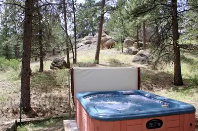 a hot tub sitting in the middle of a forest at Stonehaven Home by Rocky Mountain Resorts- #3384 in Estes Park
