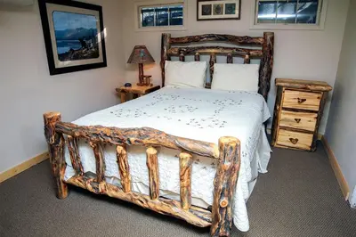 a bedroom with a large bed with a wooden frame at Stonehaven Home by Rocky Mountain Resorts- #3384 in Estes Park