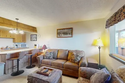 a living room with a couch and a kitchen at Hi Country Haus 6-15 in Winter Park