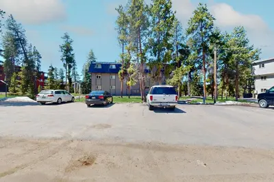 a parking lot with cars parked in front of a building at Hi Country Haus 6-15 in Winter Park