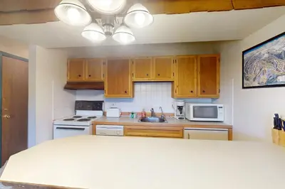 a kitchen with wooden cabinets and a counter top at Hi Country Haus 6-15 in Winter Park