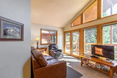 a living room with a couch and a television at Woodlands on Fall River in Estes Park