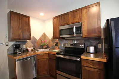 a kitchen with wooden cabinets and a stove top oven at Woodlands on Fall River in Estes Park