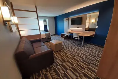 a hotel room with a couch and a bed and a desk at Microtel Inn & Suites by Wyndham Loveland in Loveland