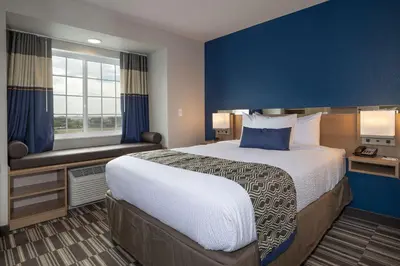 a hotel room with a large bed and a window at Microtel Inn & Suites by Wyndham Loveland in Loveland