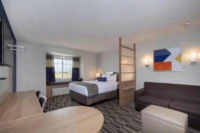 a hotel room with a bed and a couch at Microtel Inn & Suites by Wyndham Loveland in Loveland