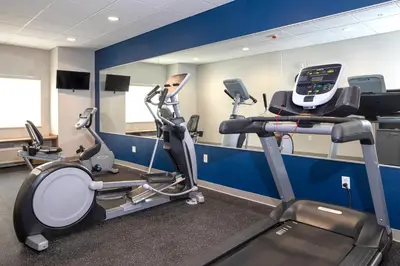 a gym with two tread machines and a treadmill at Microtel Inn & Suites by Wyndham Loveland in Loveland