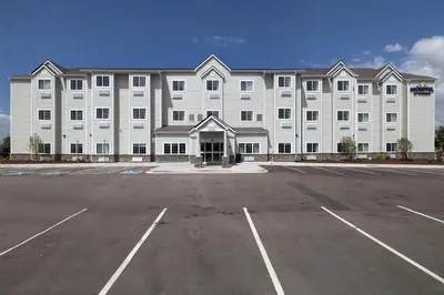 a large white building with a parking lot at Microtel Inn & Suites by Wyndham Loveland in Loveland