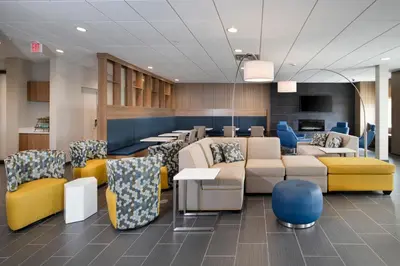 a waiting room with couches and tables and chairs at Microtel Inn & Suites by Wyndham Loveland in Loveland