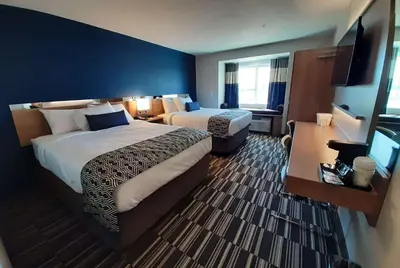 a hotel room with two beds and a television at Microtel Inn & Suites by Wyndham Loveland in Loveland