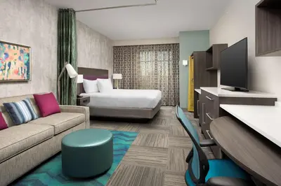 a hotel room with a couch and a bed at Home2 Suites by Hilton Denver Central Park in Denver
