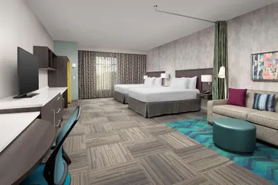 a hotel room with a bed and a couch at Home2 Suites by Hilton Denver Central Park in Denver