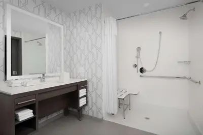 a bathroom with a sink and a shower and a mirror at Home2 Suites by Hilton Denver Central Park in Denver