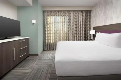 a hotel room with a bed and a flat screen tv at Home2 Suites by Hilton Denver Central Park in Denver